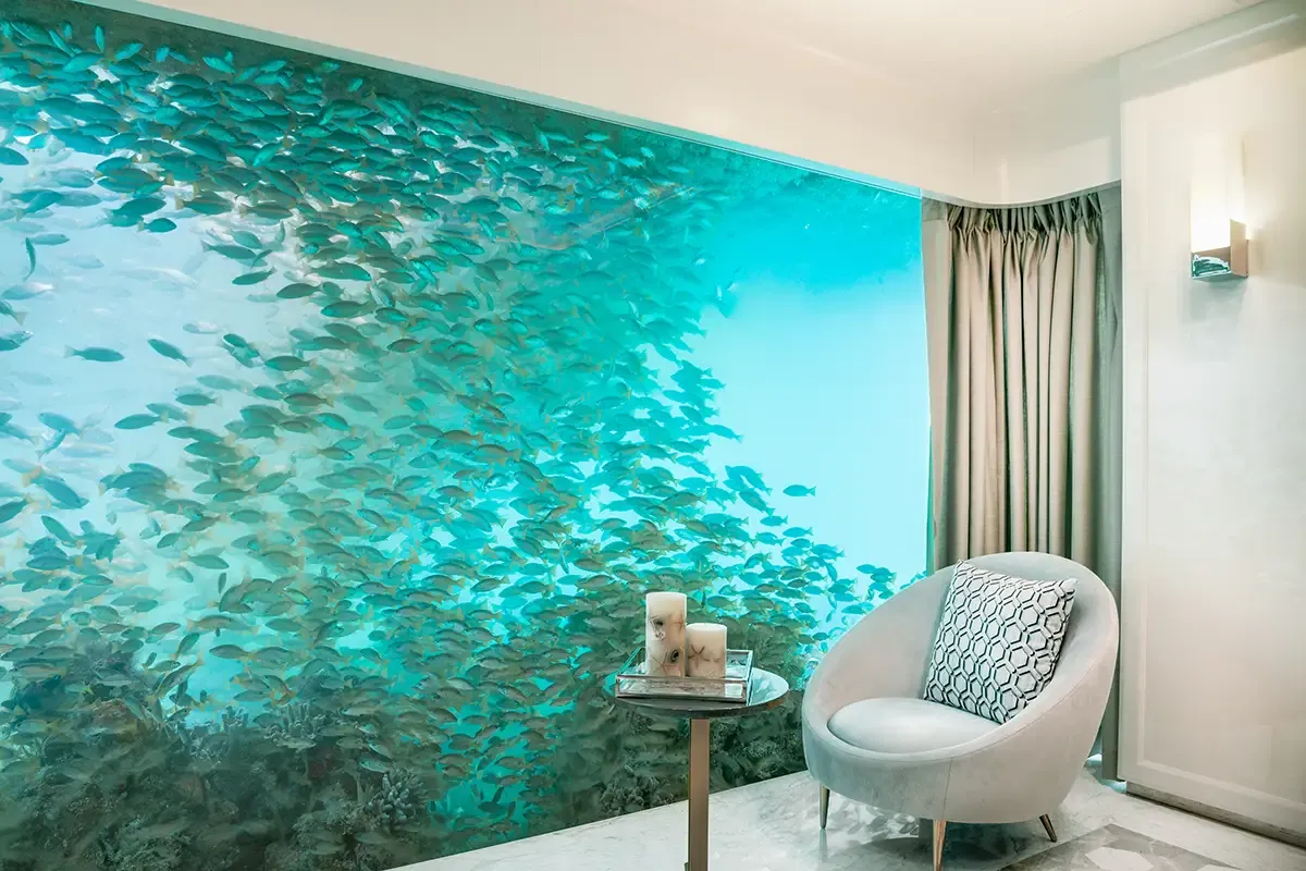 Buddha-Bar Floating Residences — underwater bedroom still with a glass wall of fish and coral