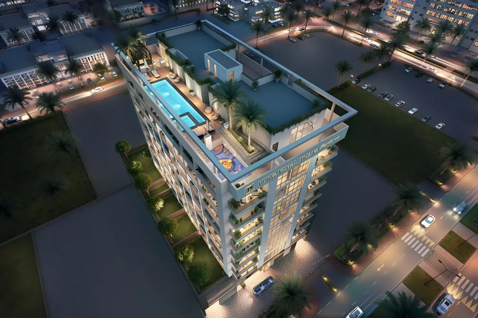 Triana Residences — night aerial of the labelled mid-rise with a rooftop pool and palms